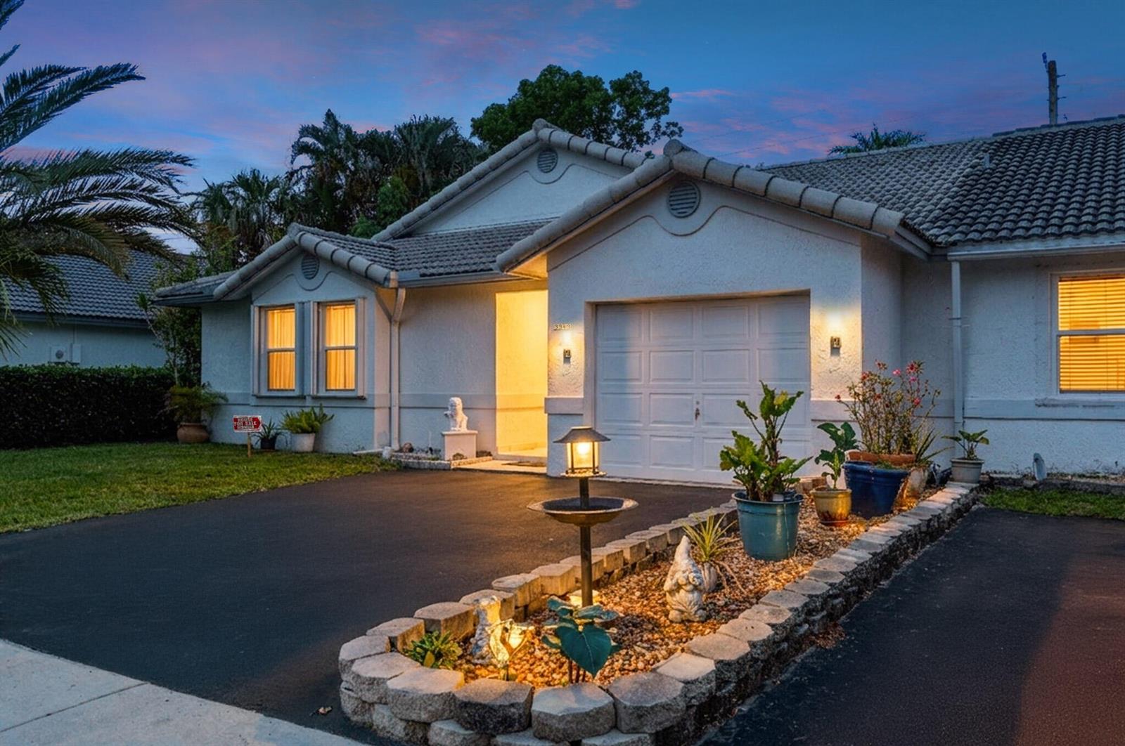A single-story house with a white stucco exterior, a garage, and a landscaped front garden — 3343 NW 79th Way, Davie FL 33024, DAVIE, FL