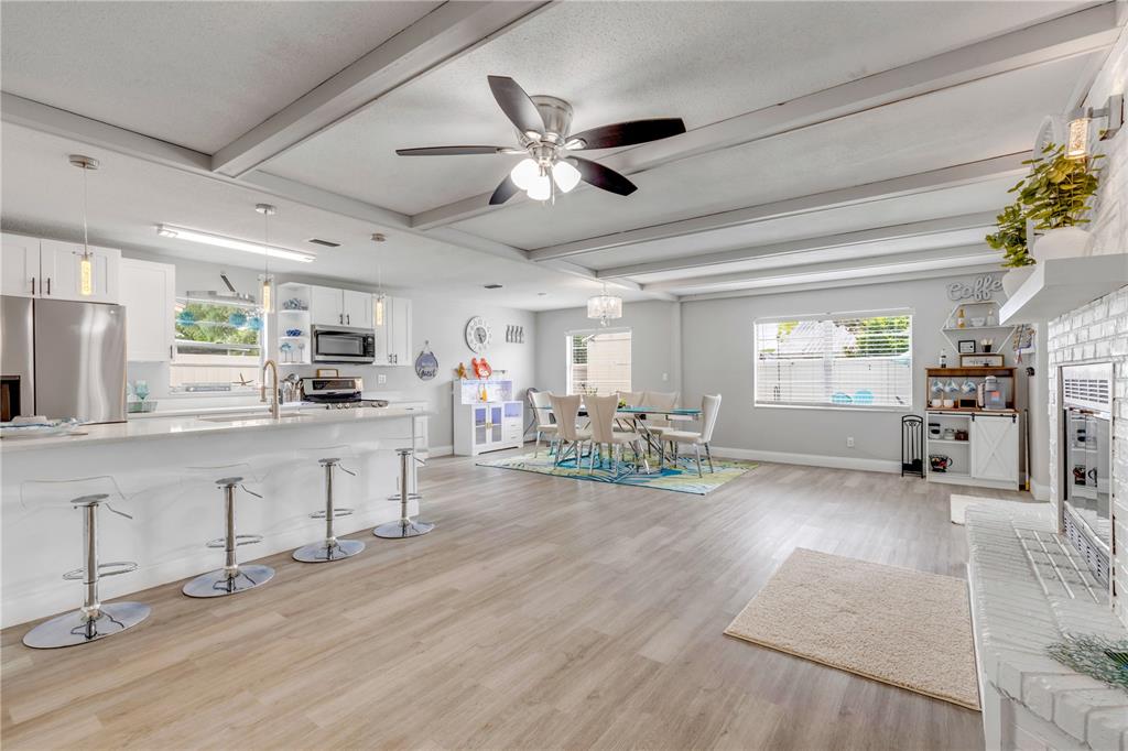 An open-concept kitchen and dining area features white cabinetry, a breakfast bar, and wood-look flooring — 2952 CARRIAGE DRIVE, SOUTH DAYTONA, FL