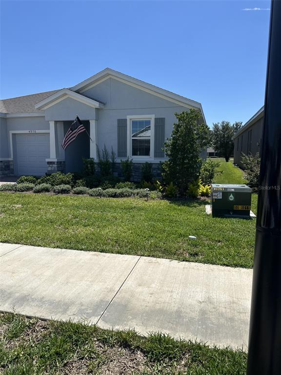 A single-story house with a gray exterior, a front-facing garage, and an American flag — 4970 NW 39TH LOOP, OCALA, FL