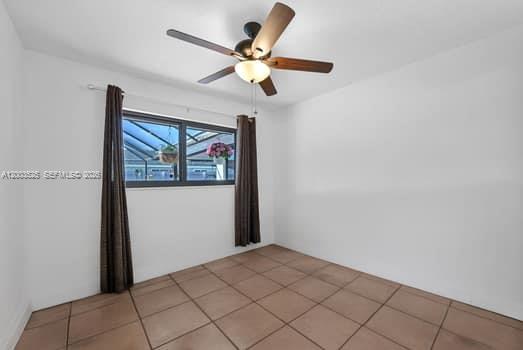 A bedroom with white walls, tile flooring, a ceiling fan, and a window with curtains — 13216 SW 45th Ln, Miami FL 33175, MIAMI, FL