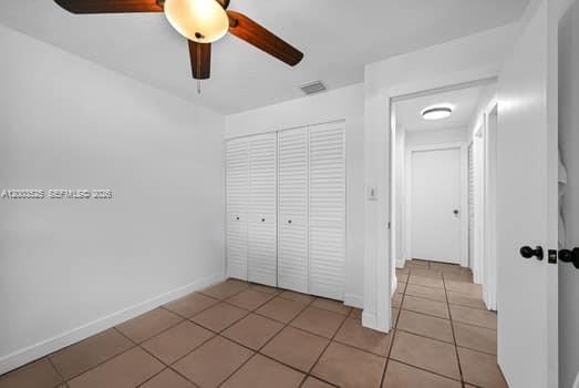 A room with white walls, tile flooring, a ceiling fan, and louvered closet doors — 13216 SW 45th Ln, Miami FL 33175, MIAMI, FL