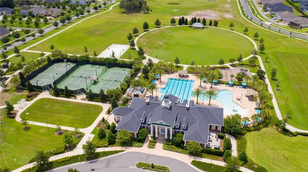 An aerial view shows a community clubhouse with a swimming pool, tennis courts, and park — 11869 SW 28TH AVENUE, GAINESVILLE, FL
