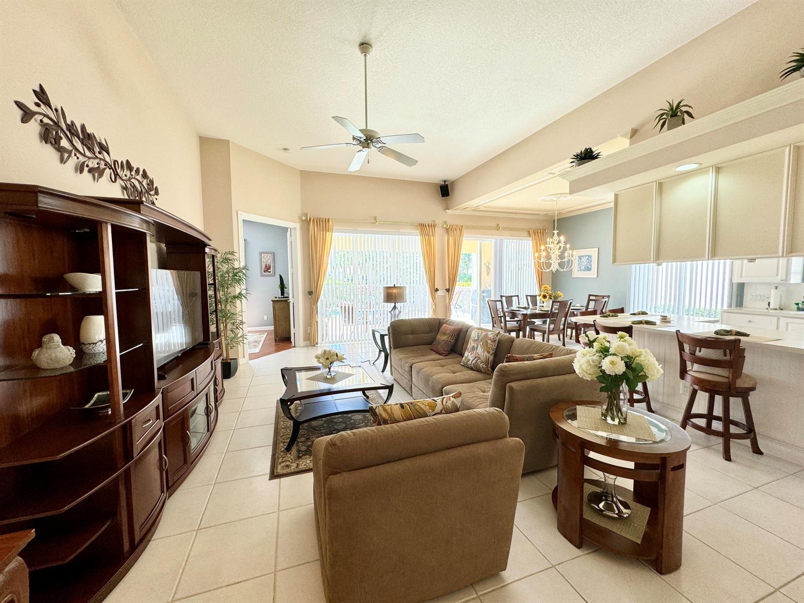 A living room with tile floors, a large sectional sofa, and an open-concept kitchen — 8262 Dominica Place, Wellington FL 33414, WELLINGTON, FL