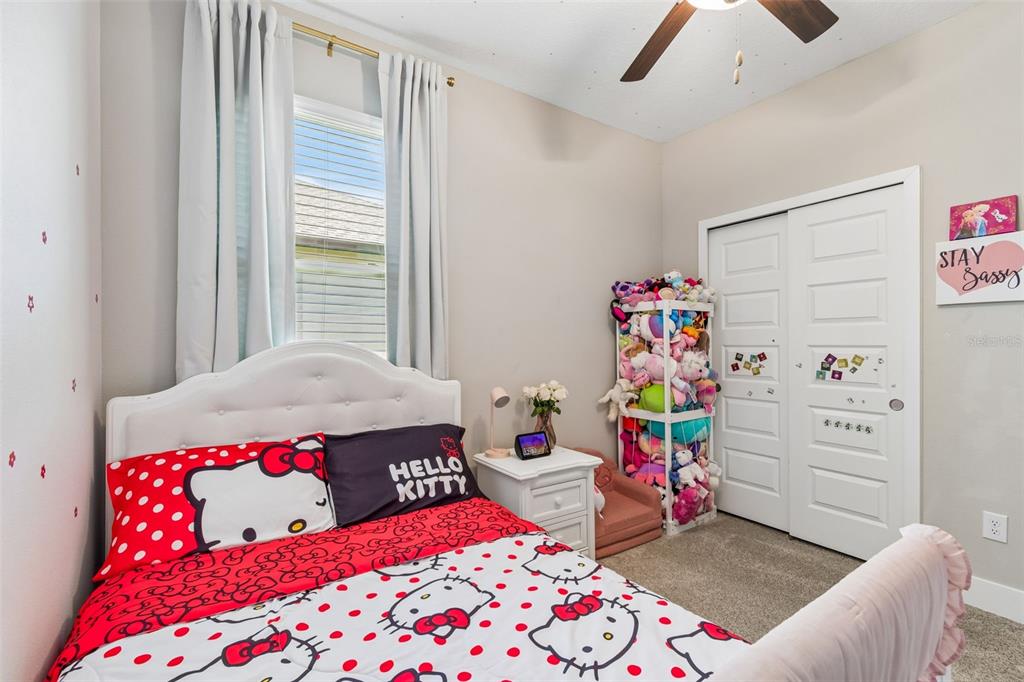 A bedroom features a Hello Kitty bed, a white nightstand, and a stuffed animal storage rack — 9911 CAMPANULA COURT, LAND O LAKES, FL
