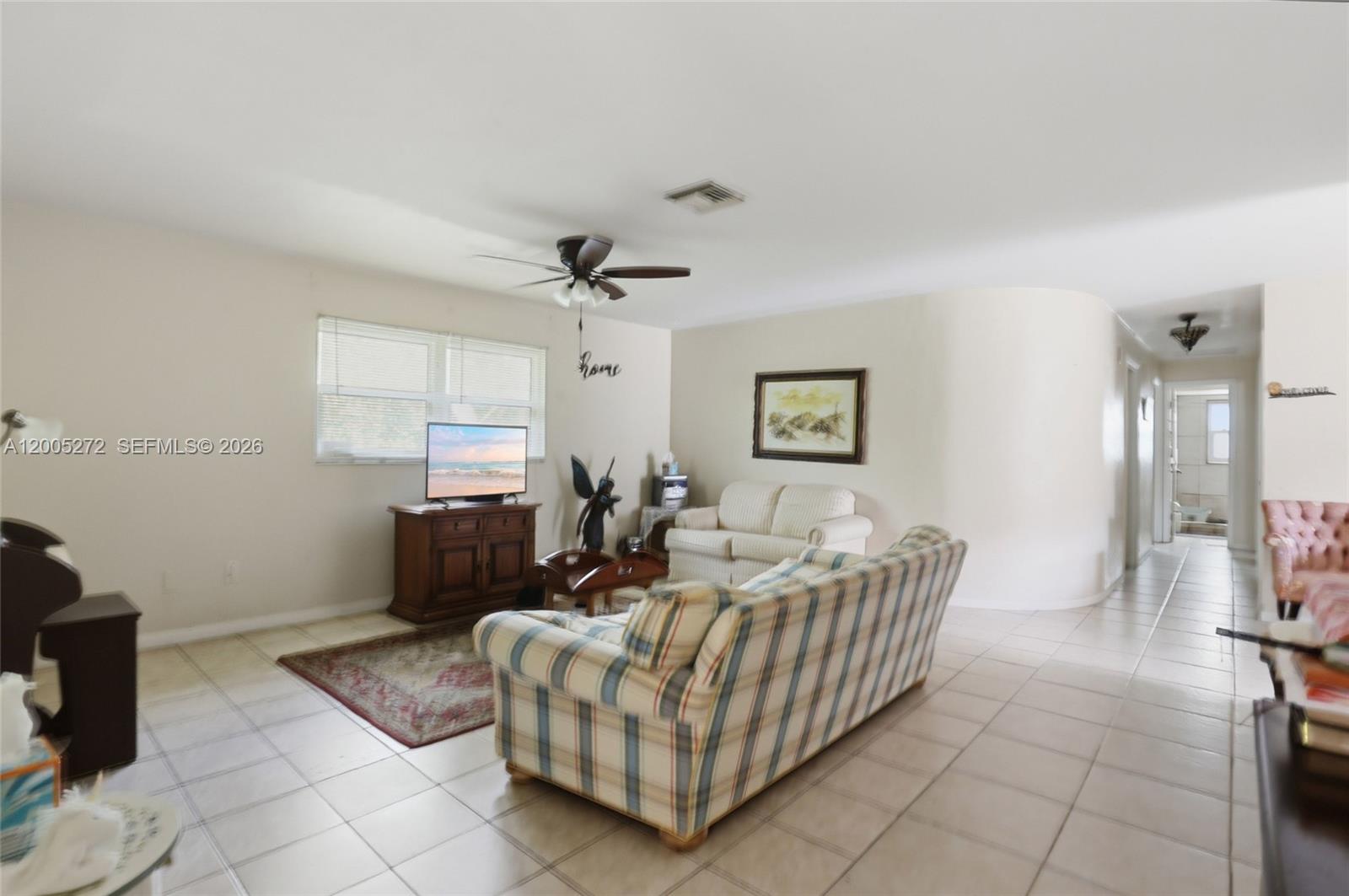 A living room features tile flooring, a ceiling fan, and two sofas — 1066 Highlands Dr, Naples FL 34103, NAPLES, FL