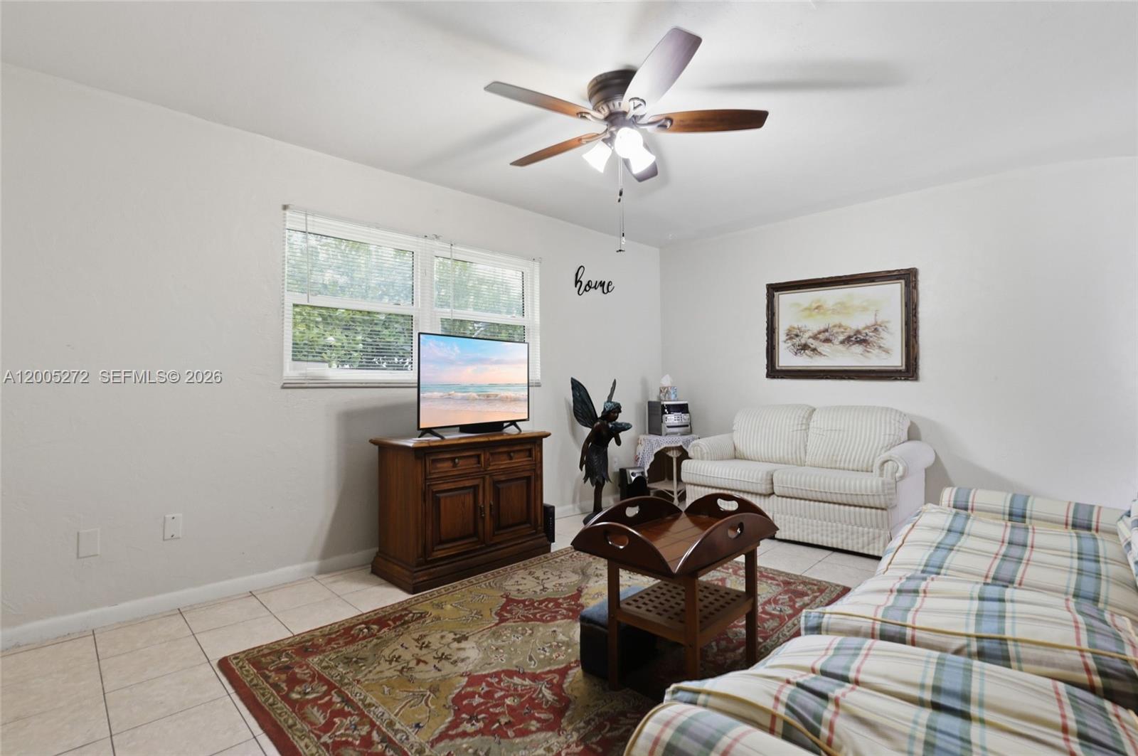 A living room features a ceiling fan, a television on a wooden stand, and furniture — 1066 Highlands Dr, Naples FL 34103, NAPLES, FL