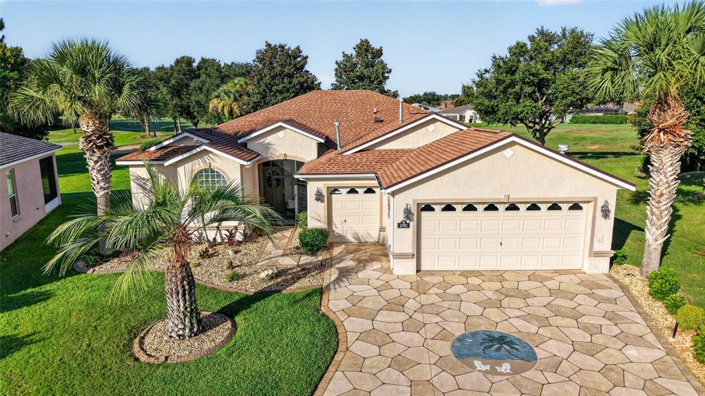 A single-story house with a stone-paved driveway, a two-car garage, and two palm trees — 1092 SW 159TH STREET, OCALA, FL