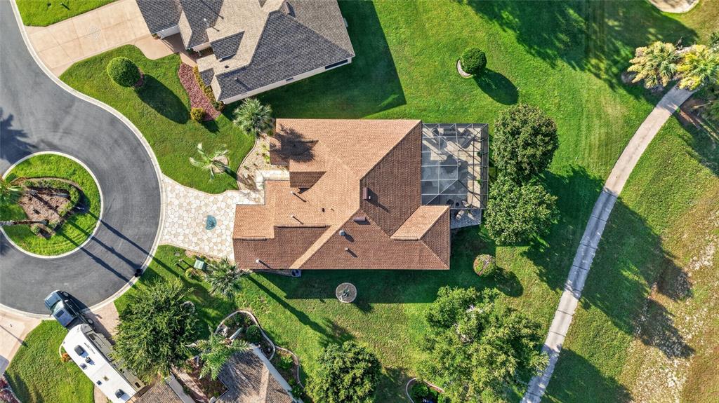 An aerial view shows a house with a brown roof, screened lanai, and paved driveway — 1092 SW 159TH STREET, OCALA, FL