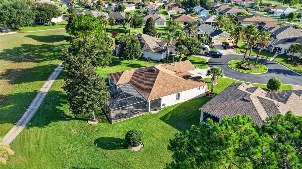 An aerial view shows a suburban house with a screened-in lanai and a large lawn — 1092 SW 159TH STREET, OCALA, FL