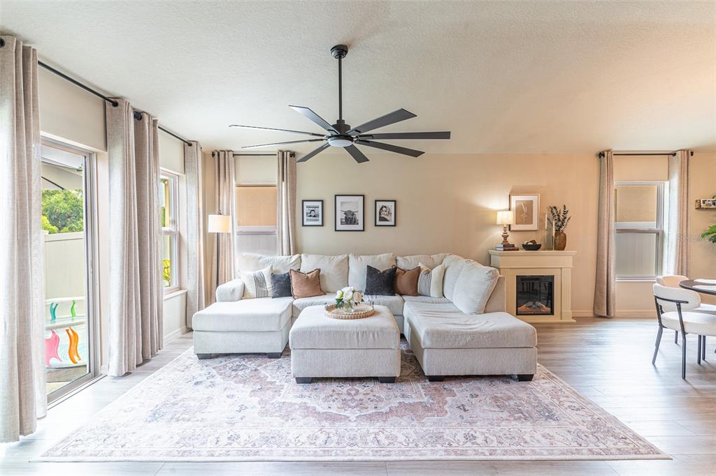 A living room features a large sectional sofa, a patterned area rug, and a ceiling fan — 615 VALRI PARK DRIVE, VALRICO, FL