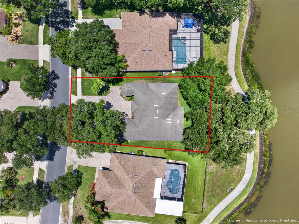 An aerial view shows a house with a red outline on a waterfront lot — 2275 RAMBLING OAKS WAY, KISSIMMEE, FL