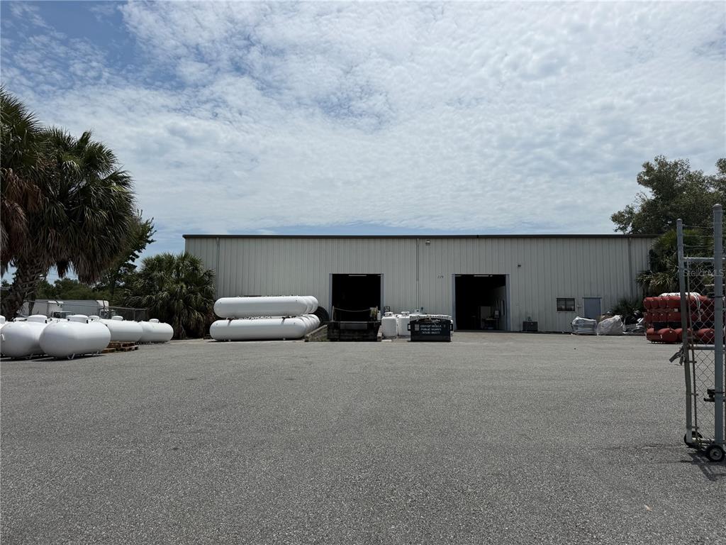 A large industrial warehouse building features two open loading bays and several propane tanks outside — 229 SW 54TH COURT, OCALA, FL