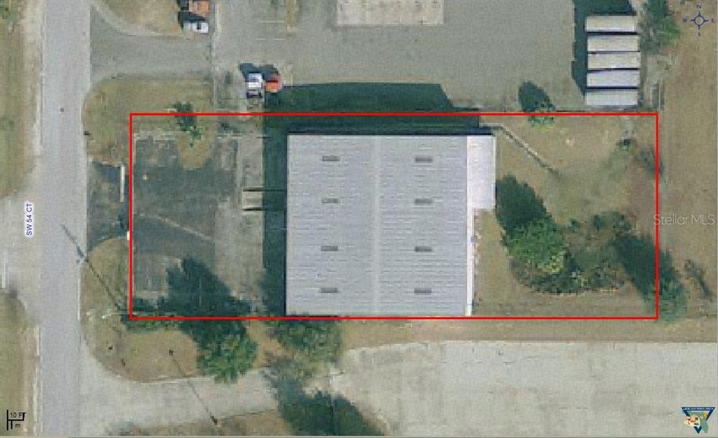This aerial view shows a rectangular commercial building with a parking lot and surrounding grounds — 229 SW 54TH COURT, OCALA, FL