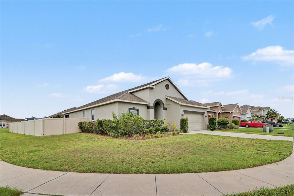 A single-story suburban house with a tan stucco exterior and a two-car garage — 5423 DOVE COTTAGE LN, ST CLOUD, FL
