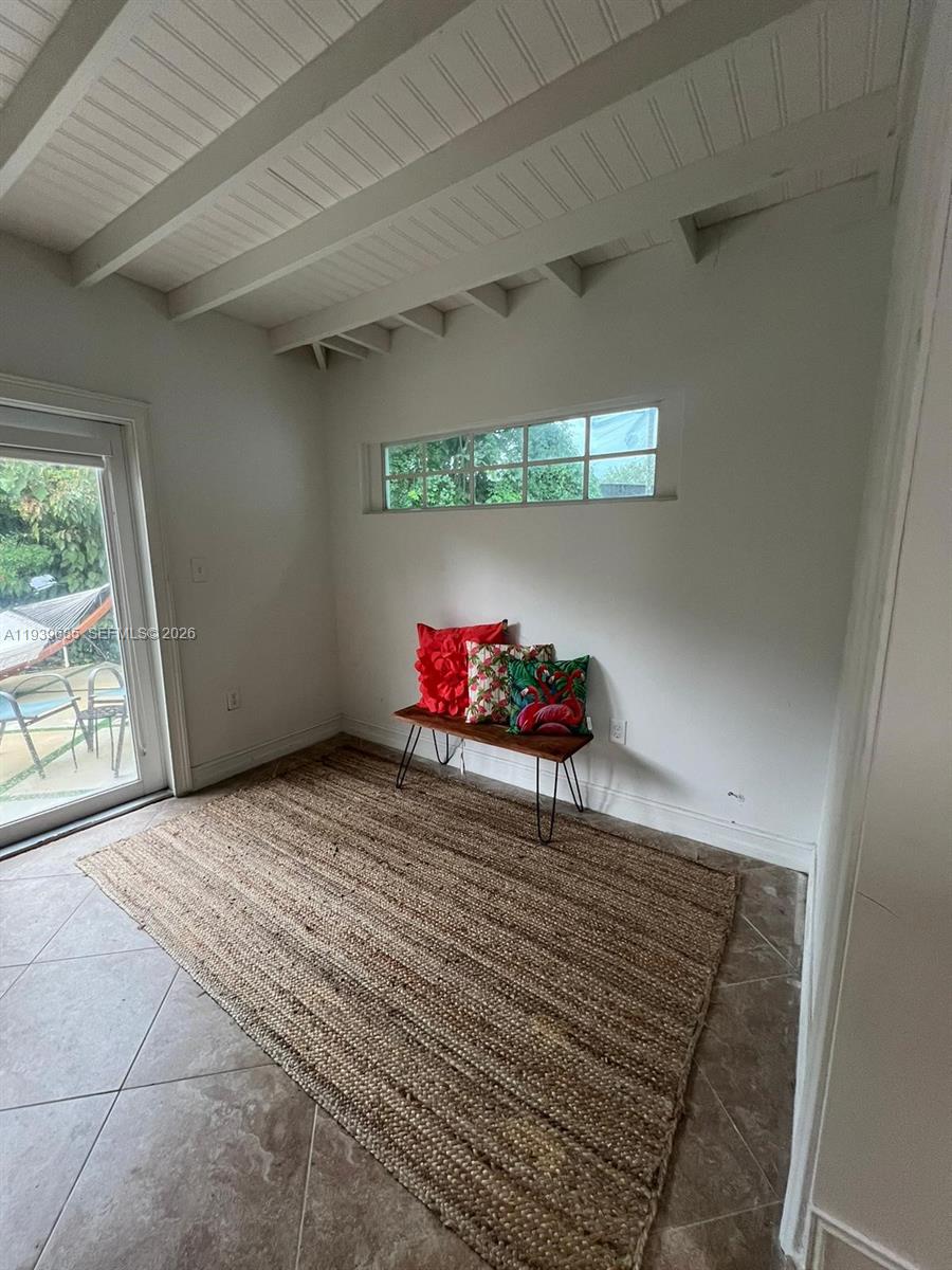 A small room features a tiled floor, a jute rug, a bench, and a glass door — 1110 NE 119th, Biscayne Park FL 33161, BISCAYNE PARK, FL