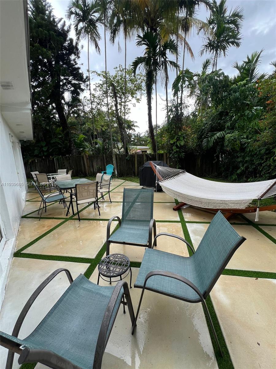 A patio features concrete pavers with grass strips, outdoor furniture, and a hammock — 1110 NE 119th, Biscayne Park FL 33161, BISCAYNE PARK, FL