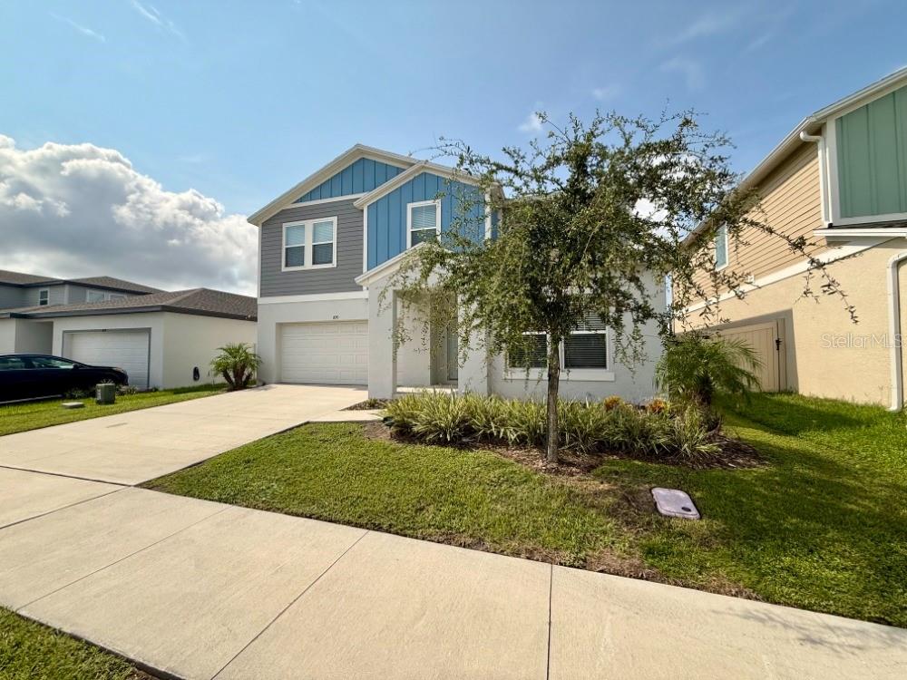 A two-story suburban house with a blue and gray facade and a concrete driveway — 870 SAND SEA PLACE, HAINES CITY, FL