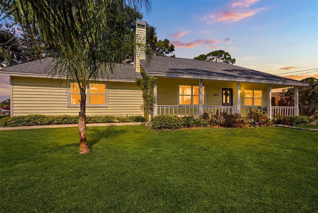 A yellow single-story house with a front porch and a chimney sits on a lawn — 4821 EGRET ROAD, VENICE, FL