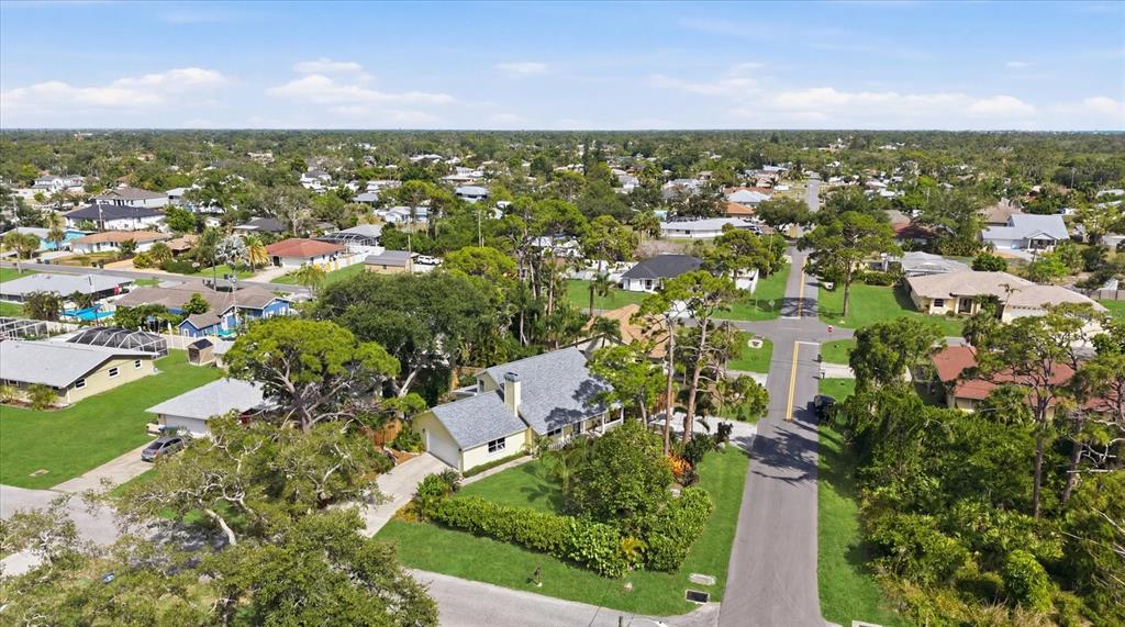 An aerial view shows a suburban neighborhood with single-family homes, green lawns, and paved streets — 4821 EGRET ROAD, VENICE, FL