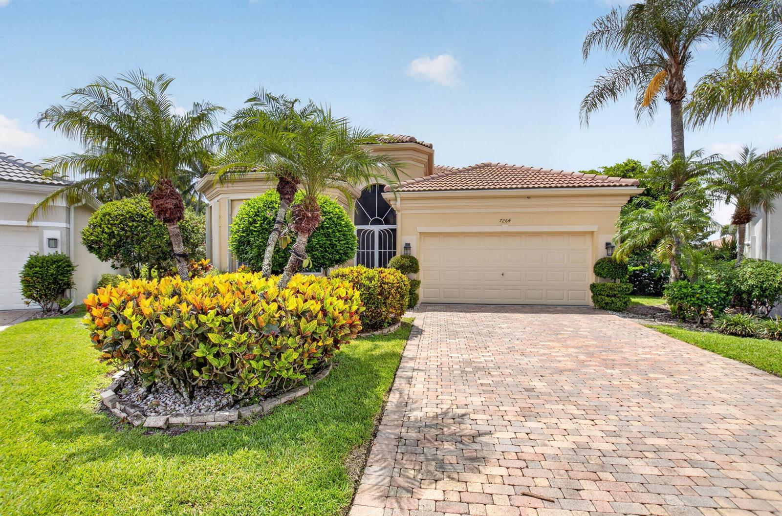 A single-story house with a beige stucco exterior, a tiled roof, and a brick driveway — 7264 Cataluna Circle, Delray Beach FL 33446, DELRAY BEACH, FL