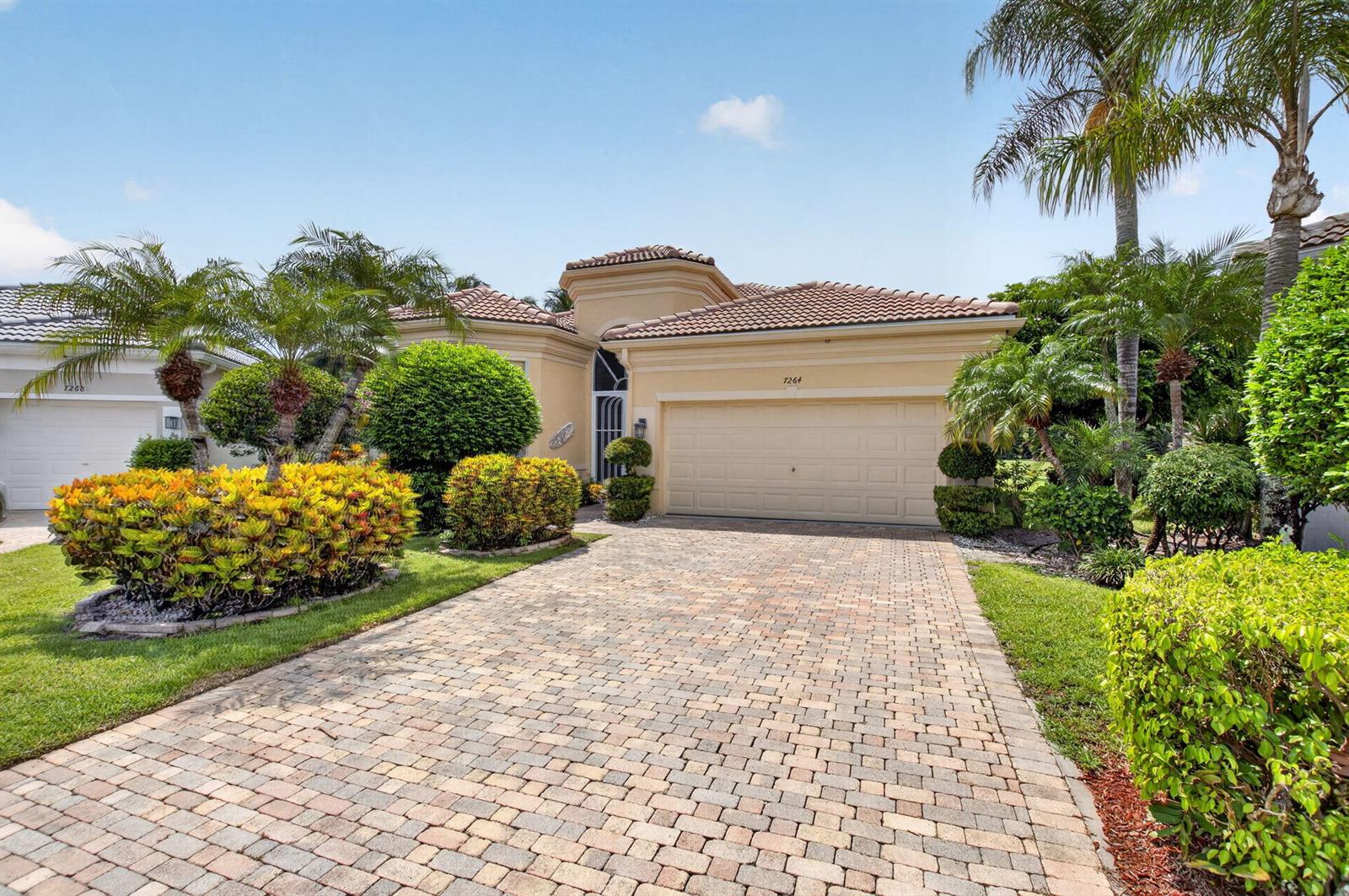 A single-story house with a beige stucco exterior, a tile roof, and a paved driveway — 7264 Cataluna Circle, Delray Beach FL 33446, DELRAY BEACH, FL