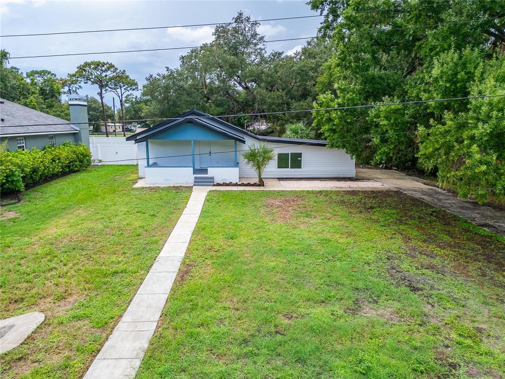A single-story house with a blue-accented front porch and a concrete walkway in the yard — 8809 DYER ROAD, RIVERVIEW, FL