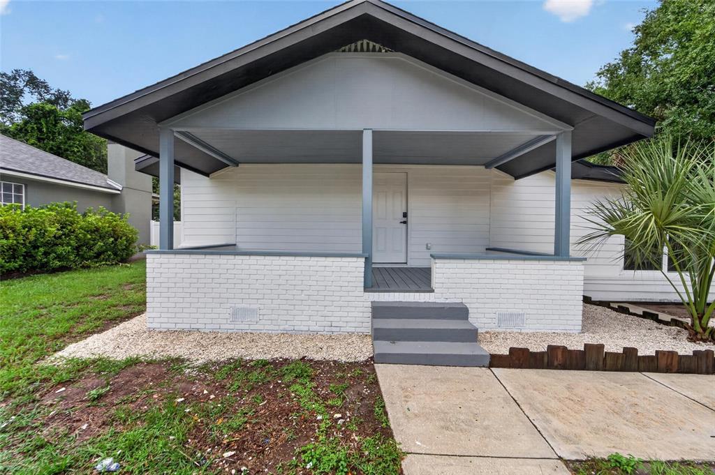 A white house with a covered front porch, brick base, and gray painted steps — 8809 DYER ROAD, RIVERVIEW, FL
