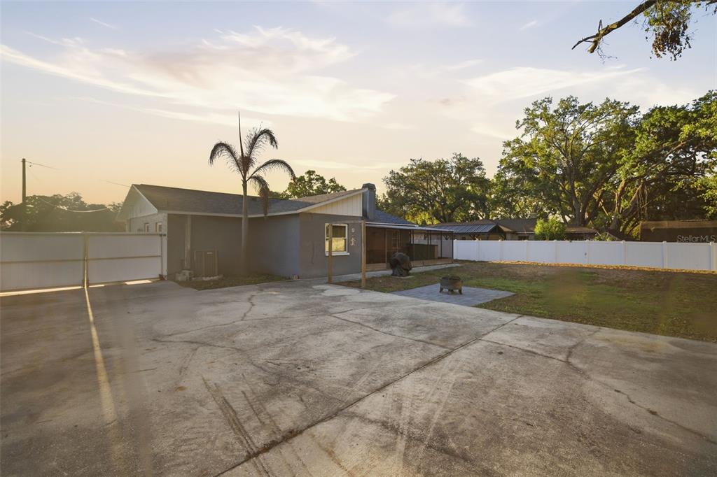 A concrete driveway leads to the side of a house with a fenced backyard — 7403 PROVIDENCE ROAD, RIVERVIEW, FL