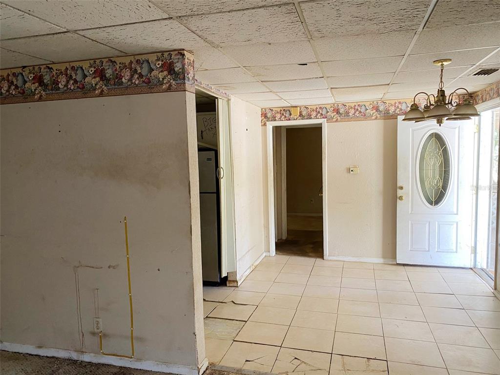 A single-story white house with a front porch and a concrete driveway under large trees — 3213 E DIANA STREET, TAMPA, FL
