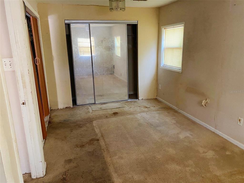 A white house with a metal roof, a front porch, and a concrete driveway — 3213 E DIANA STREET, TAMPA, FL