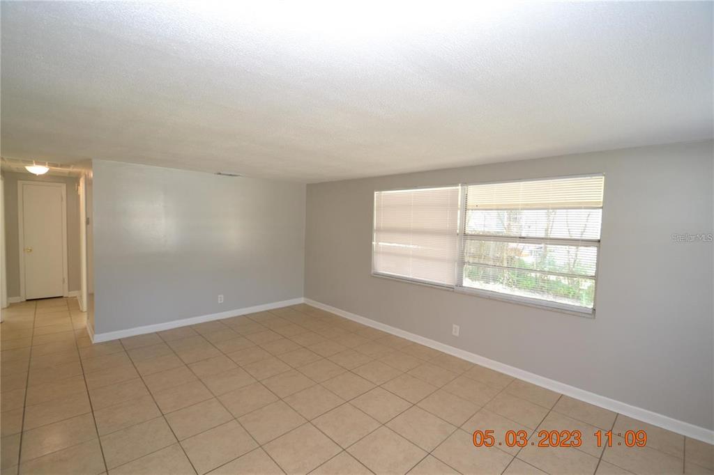 An empty room with light gray walls, beige tile flooring, and a large window with blinds — 300 MIDWOOD DRIVE, PLANT CITY, FL