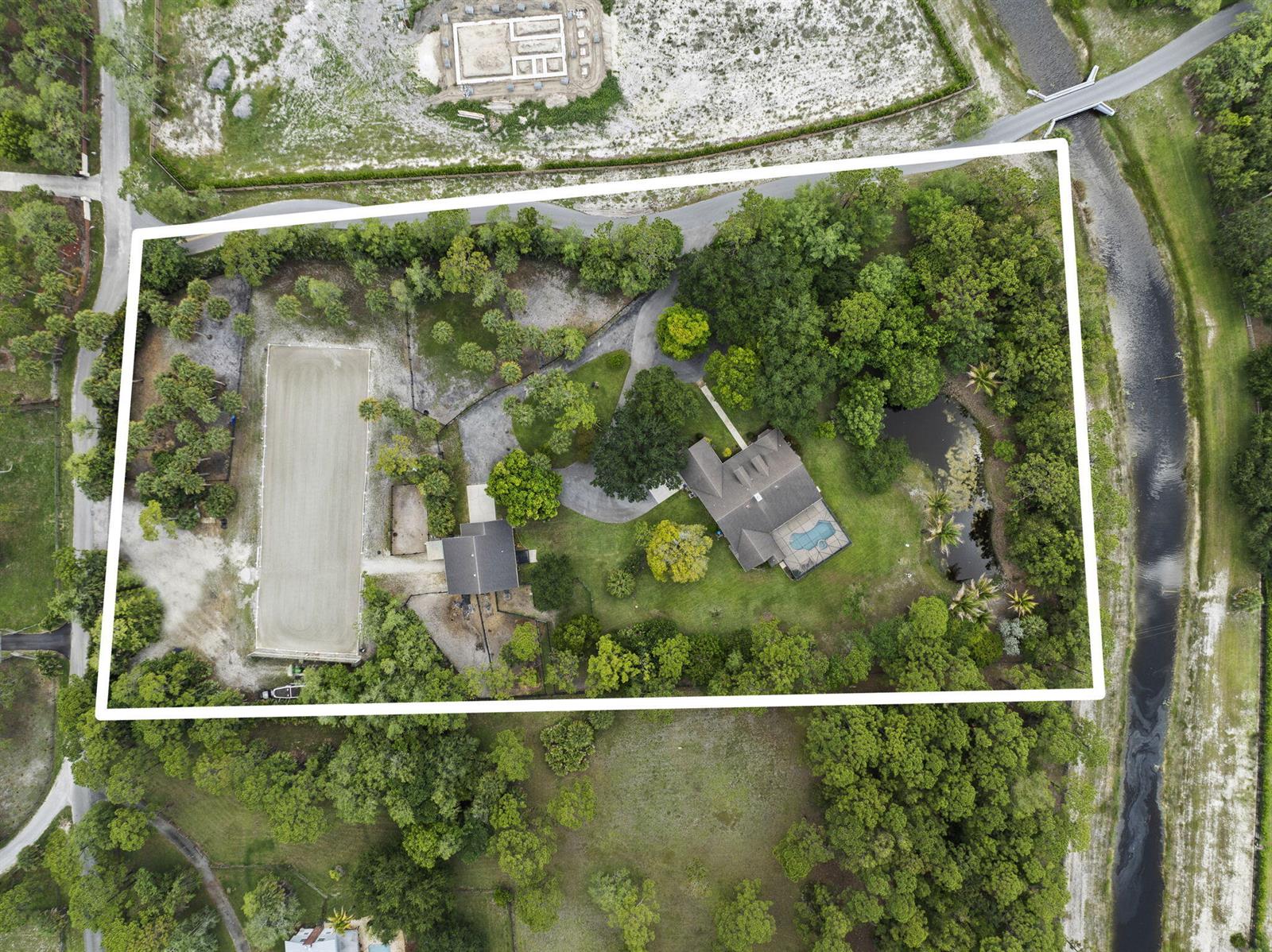 An aerial view shows a house with a pool, a riding arena, and surrounding trees — 17225 Mare Lane, Loxahatchee FL 33470, LOXAHATCHEE, FL