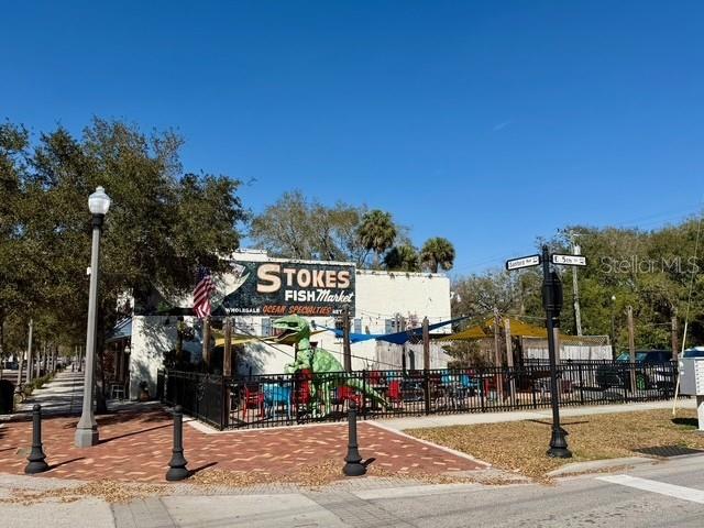 An exterior view of Stokes Fish Market featuring a large green dinosaur statue — 417 & 419 SANFORD AVENUE, SANFORD, FL