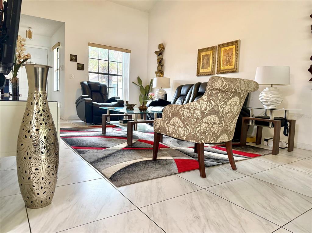 A living room features white tile floors, a patterned area rug, and contemporary furniture — 2139 BALBOA WAY, KISSIMMEE, FL