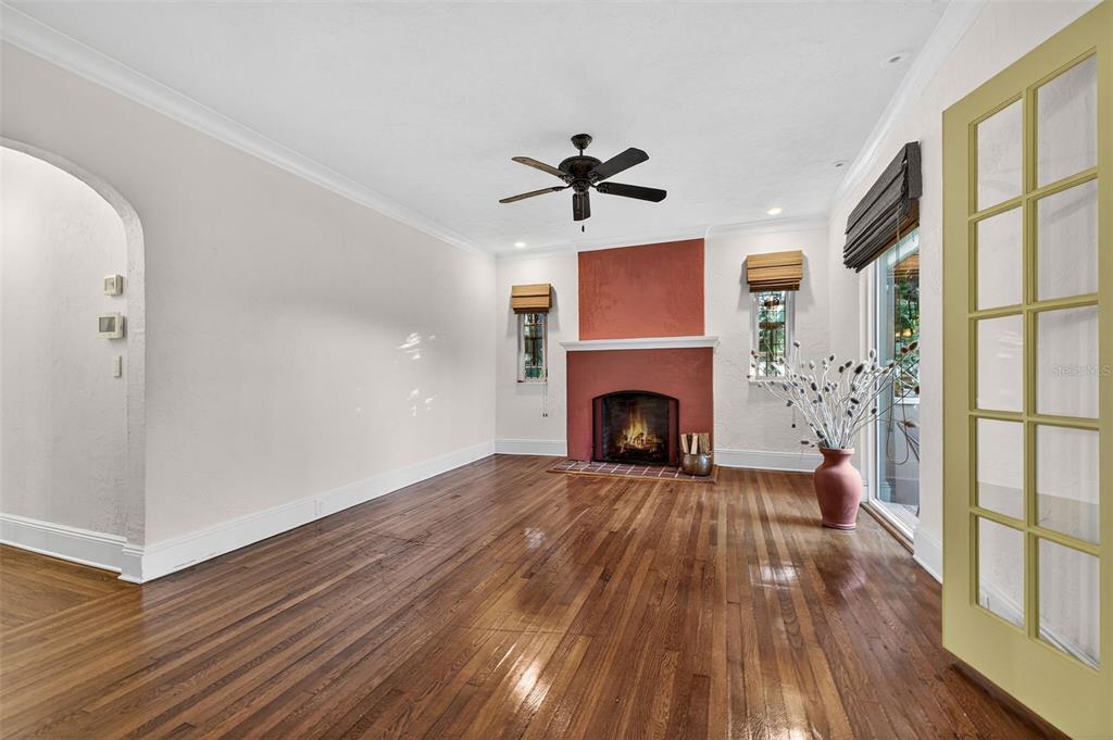 A living room features hardwood floors, a red fireplace, and a yellow French door — 745 16TH AVENUE NE, ST PETERSBURG, FL