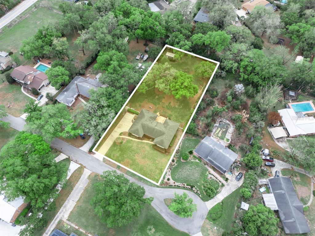 An aerial view shows a house on a large, tree-filled lot with a white outline — 1709 VIRGINIA COURT, LAKELAND, FL