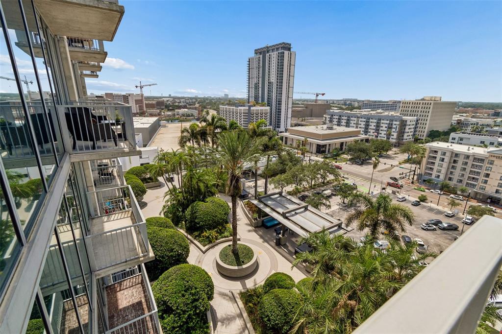 A high-angle view from a balcony overlooking a landscaped courtyard and surrounding city buildings — 777 N ASHLEY DRIVE UNIT 1213, TAMPA, FL