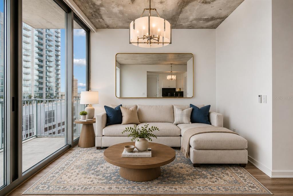 A living room features a sectional sofa, round coffee table, and a large wall mirror — 777 N ASHLEY DRIVE UNIT 1213, TAMPA, FL