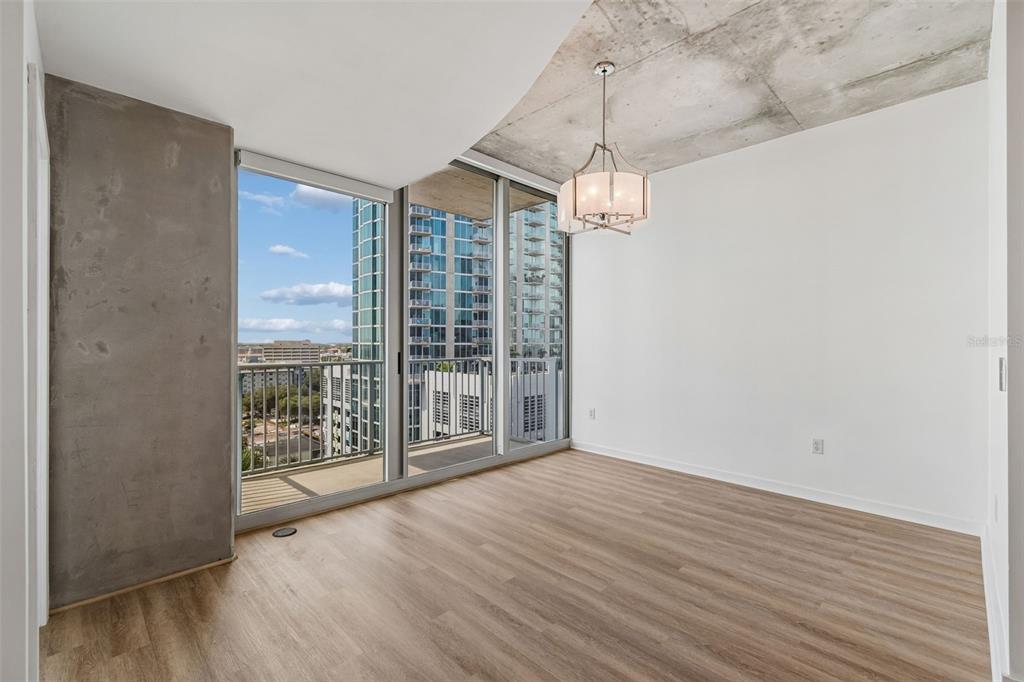 An empty room with wood-look flooring, a concrete ceiling, a chandelier, and floor-to-ceiling windows — 777 N ASHLEY DRIVE UNIT 1213, TAMPA, FL