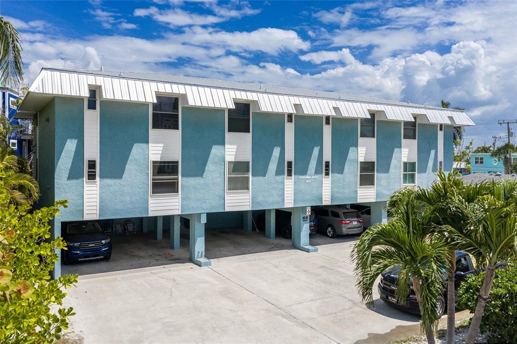 A blue, two-story apartment building with elevated parking underneath and a white metal roof — 205 HIGHLAND AVENUE UNIT 2, BRADENTON BEACH, FL