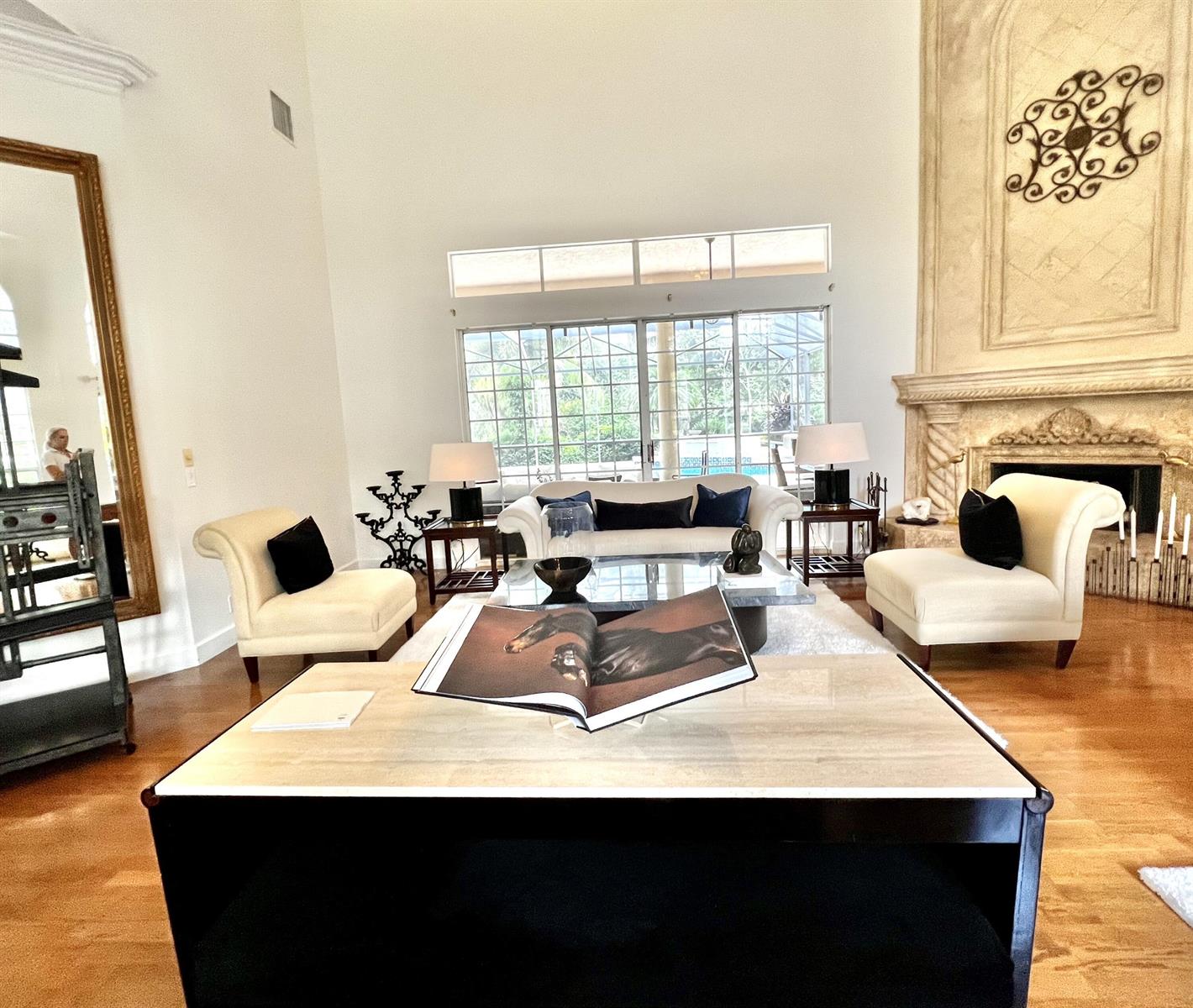 A spacious living room features a stone fireplace, cream furniture, and a large coffee table — 2050 Windsock Way, Wellington FL 33414, WELLINGTON, FL