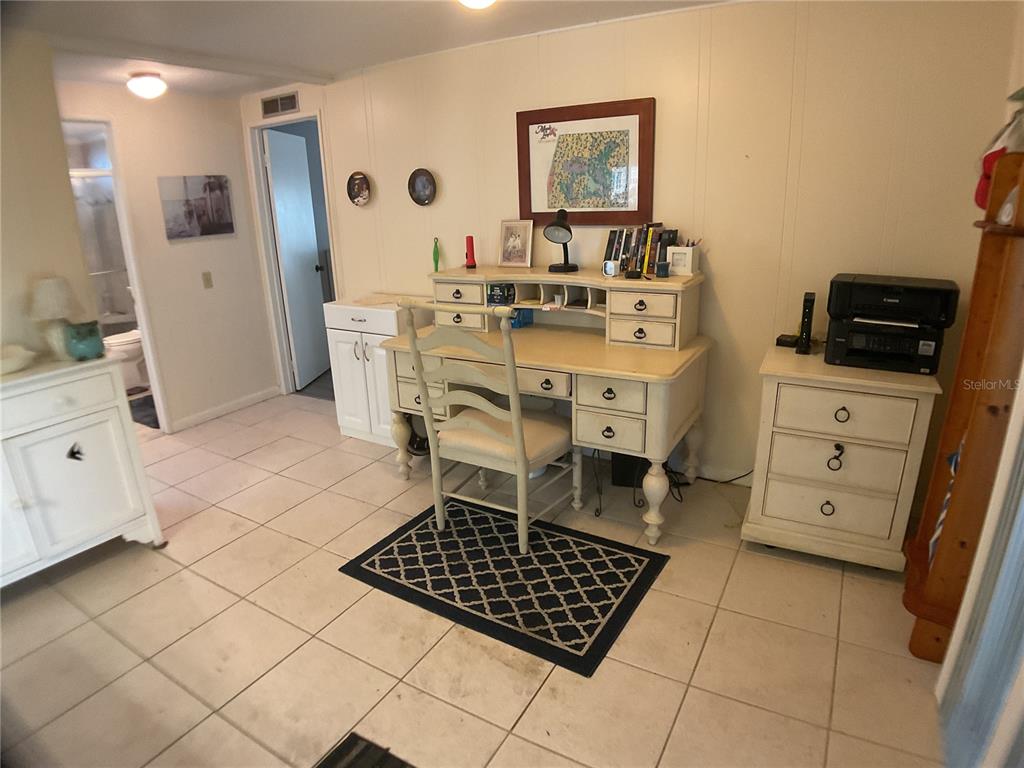 A home office features a white desk, a matching chair, and a printer on a cabinet — 2100 KINGS HIGHWAY UNIT 47, PORT CHARLOTTE, FL