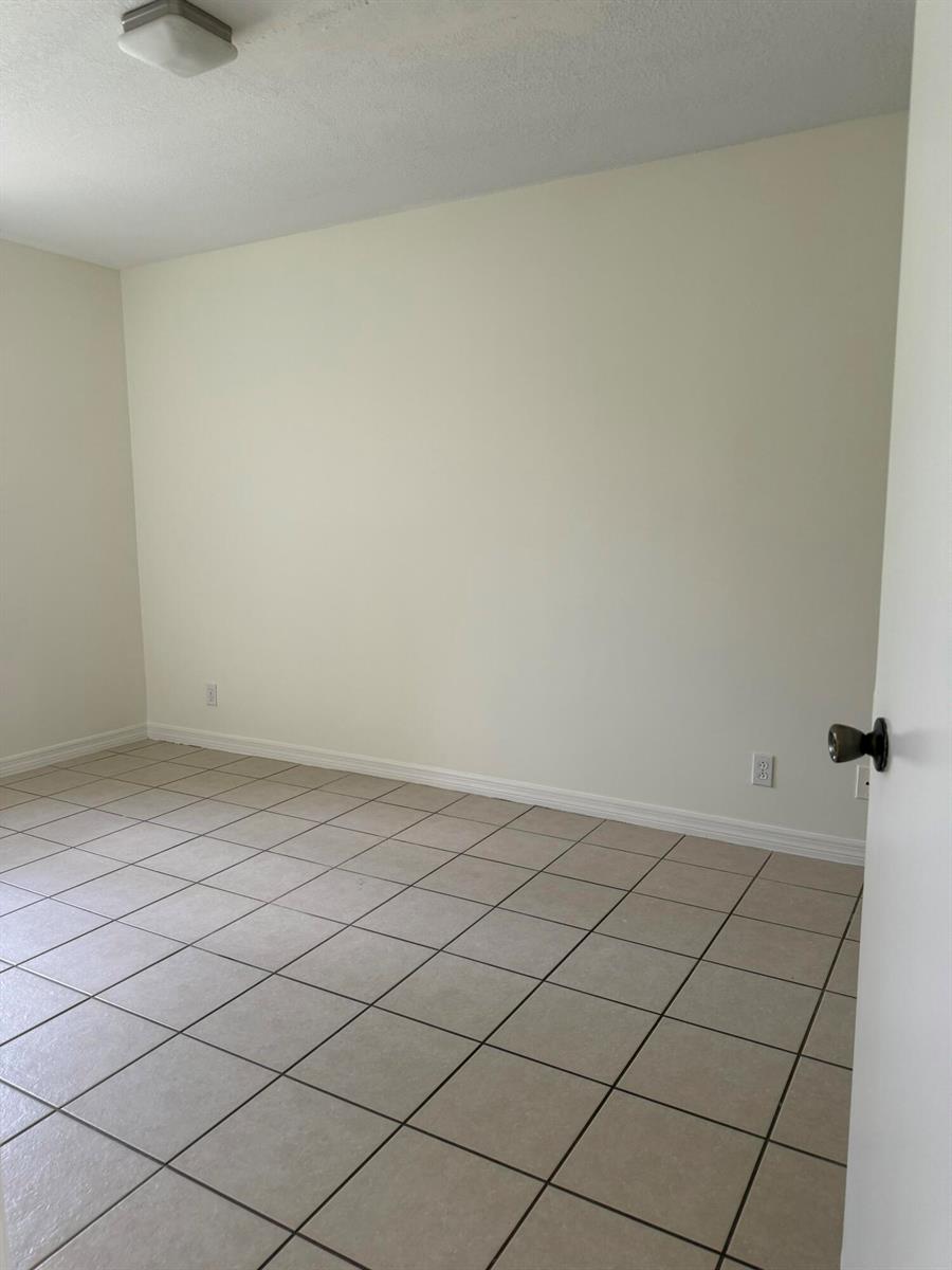 An empty room features light-colored walls, a white ceiling, and beige square floor tiles — 11289 SW 18th Court, Miramar FL 33025, MIRAMAR, FL