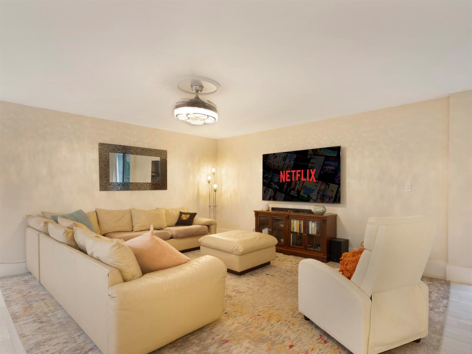 A living room features a beige sectional sofa, a recliner, and a wall-mounted television — 955 Egret Circle # 102, Delray Beach FL 33444, DELRAY BEACH, FL