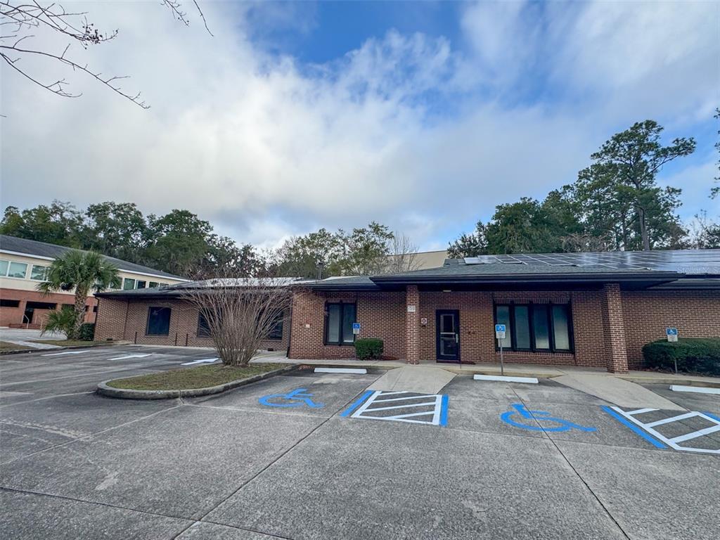 A single-story brick commercial building features a parking lot with designated handicap spaces — 7510 NW 4TH BOULEVARD, GAINESVILLE, FL