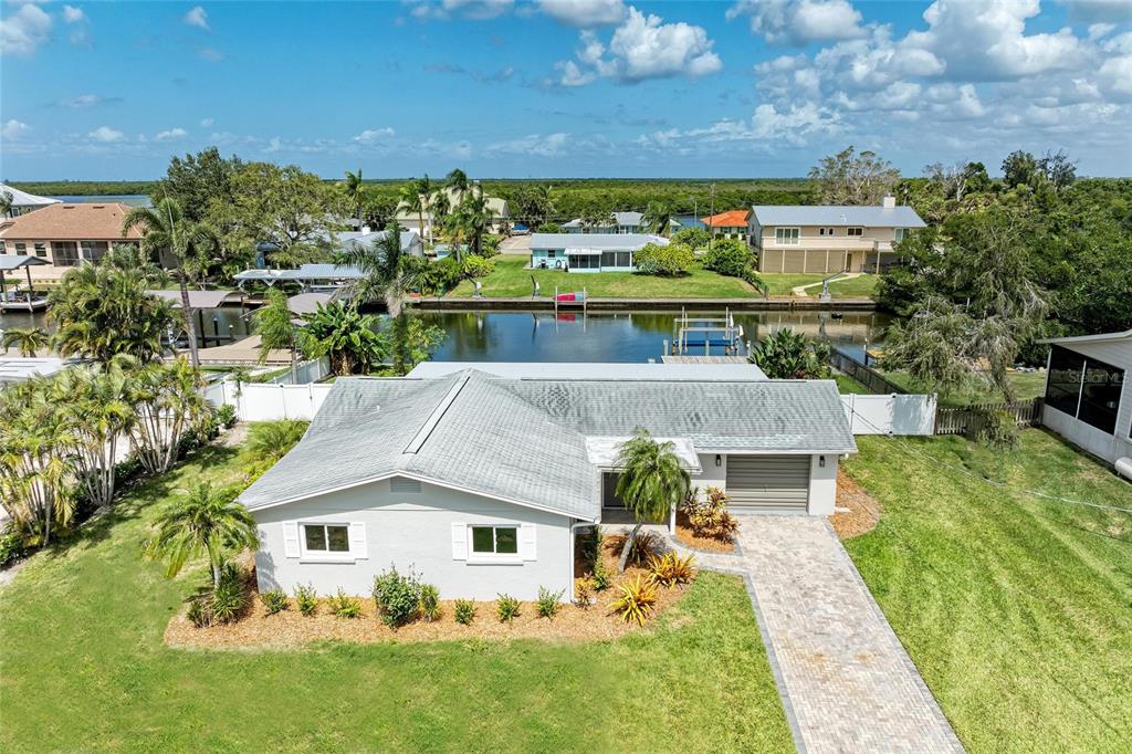 An aerial view of a single-story house with a gray roof, garage, and canal access — 4412 DOLPHIN LANE, PALMETTO, FL