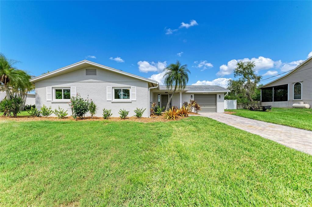 A single-story house with a light-colored exterior, a paved driveway, and a front lawn — 4412 DOLPHIN LANE, PALMETTO, FL