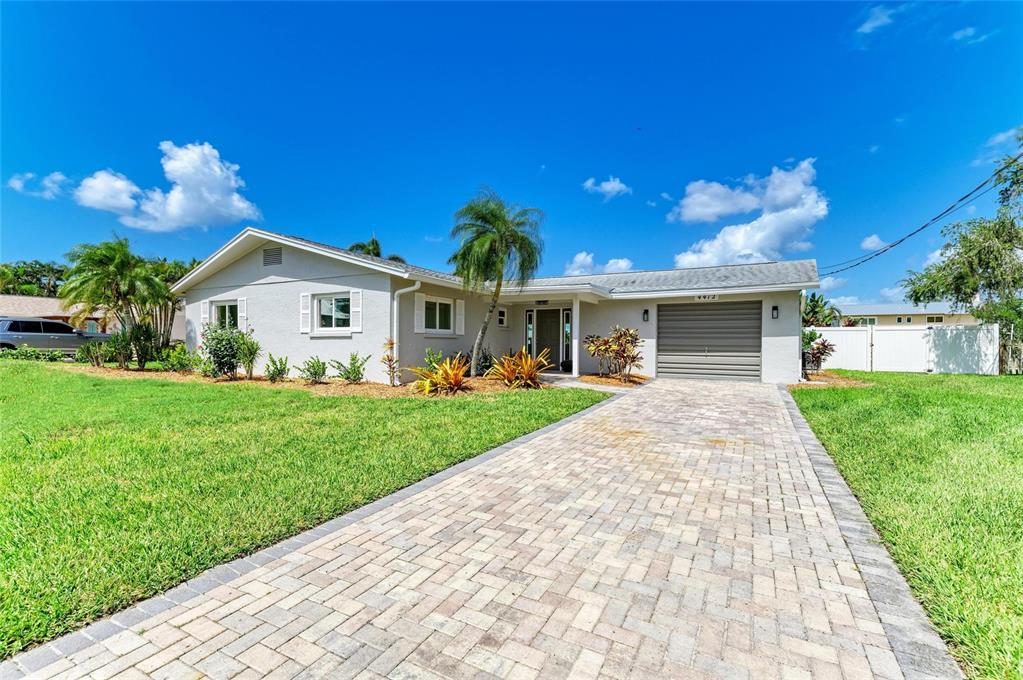 A single-story house with a paved driveway, a garage, and a green lawn — 4412 DOLPHIN LANE, PALMETTO, FL