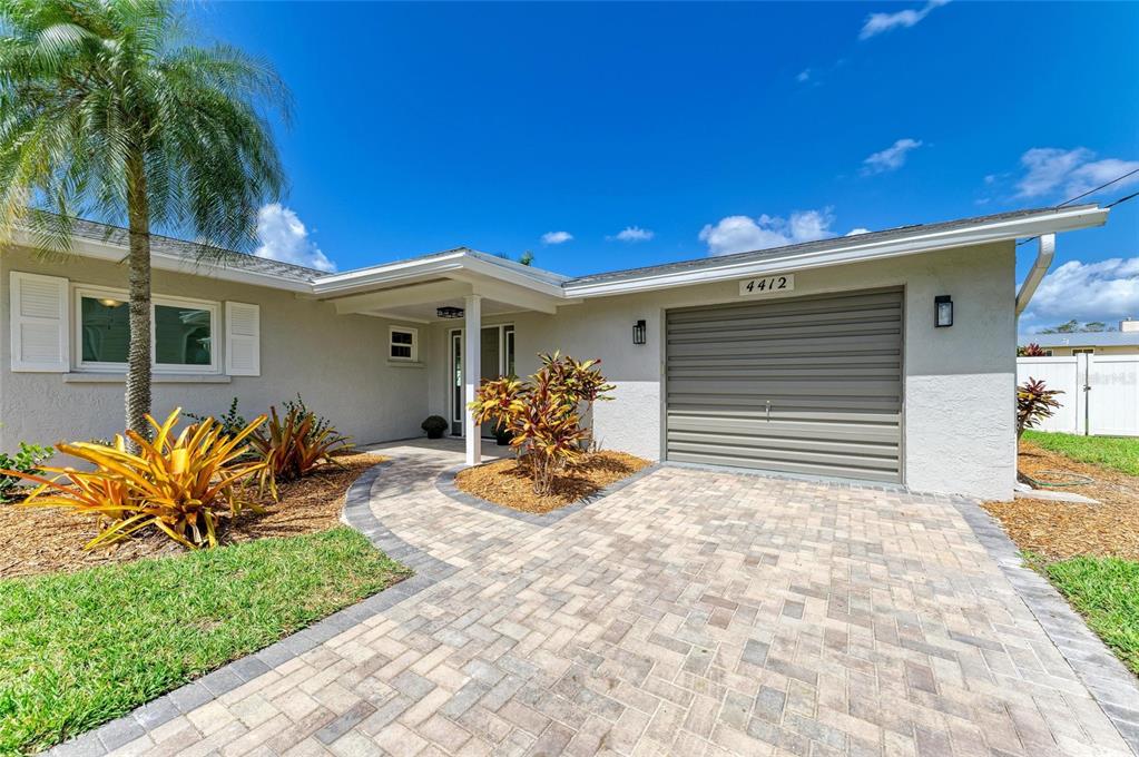 A single-story house exterior features a paved driveway, a garage, and a landscaped front yard — 4412 DOLPHIN LANE, PALMETTO, FL