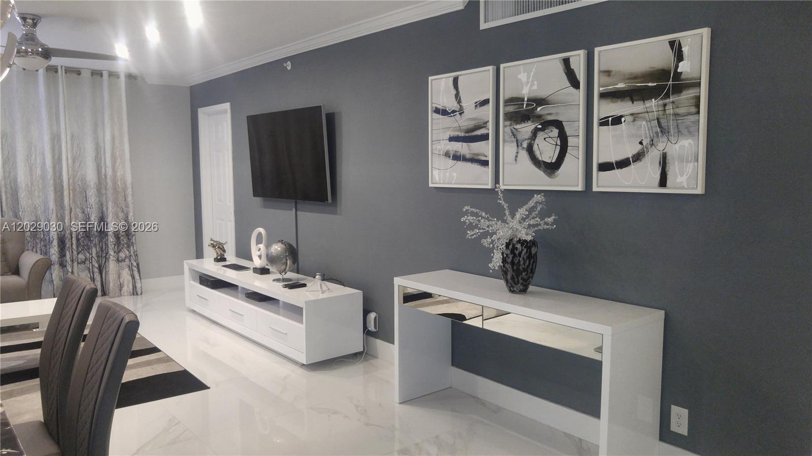 A modern living room features a gray accent wall, white furniture, and abstract wall art — 2501 S Ocean Dr # L04, Hollywood FL 33019, HOLLYWOOD, FL